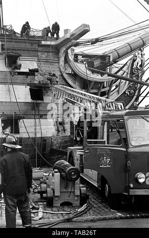 AJAXNETPHOTO. 27Febbraio, 1973. PORTSMOUTH,Inghilterra - il fuoco nel foro! - I membri di Portsmouth città VIGILI DEL FUOCO LOTTA PER SPEGNERE UN INCENDIO nell'ammiraglio Horatio Nelson la famosa Trafalgar FLAGSHIP H.M.S. La vittoria, iniziato mentre restauratori sono state rimuovendo la vecchia vernice dall'interno della sezione di prua. Foto:JONATHAN EASTLAND/AJAX REF:357309 2 Foto Stock