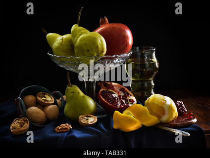 Natura morta con melograno, limone, bicchiere di vino, pera, noce. Ombre scure, frutti nello stile di artisti olandesi. Sembra vecchio europeo vintage Foto Stock