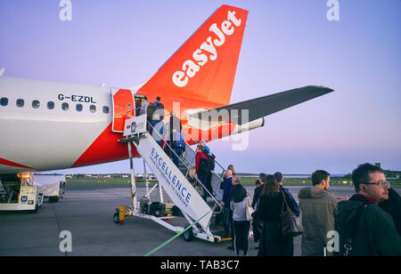 I passeggeri di salire a bordo di un aereo EasyJet utilizzando le porte posteriori all'Aeroporto di Ronaldsway, Isola di Man Foto Stock
