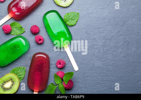 Ghiaccioli di frutta con ghiaccio di kiwi e lamponi Foto Stock