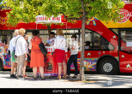 I turisti acquistano i biglietti per un tour hop-on hop-off sightseeing bus tour di Siviglia, regione Andalusia, Spagna Foto Stock