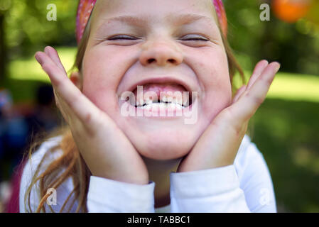 Divertimento close up ritratto di una giovane ragazza bionda che mostra off il gap nei suoi denti con un grande sorriso Foto Stock