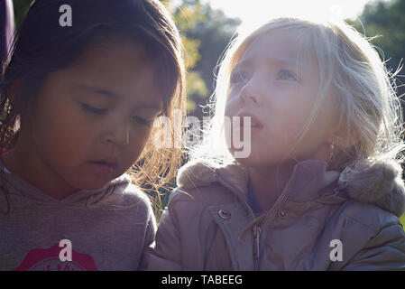 Close up ritratto di due giovani ragazze BBF è uno con i capelli biondi e gli occhi blu e una ragazza asiatica Foto Stock