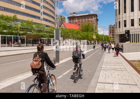 Montreal, Canada - 21 Maggio 2019: Le persone sono in sella bici su una pista ciclabile su De Maisonneuve Boulevard. Foto Stock