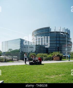 Strasburgo, Francia - 23 Maggio 2019: giovani fanciulle spensierate avente la lettura di divertimento saltando di scattare le foto di fronte all edificio del Parlamento europeo a Strasburgo un giorno prima del 2019 sulle elezioni per il Parlamento europeo Foto Stock