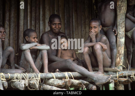 Asmat persone: gruppi etnici che vivono nella provincia di Papua di Indonesia, lungo il mare Arafura. Madre e bambini, villaggio di Pirien. Fotografia scattata Foto Stock