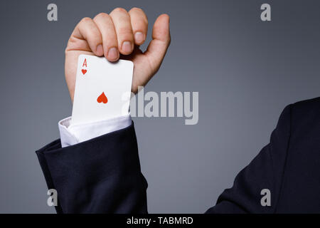 Dipendenza da gioco concetto. L uomo è nascosto un carta di asso nella manica della sua giacca durante il suo gioco. Foto Stock