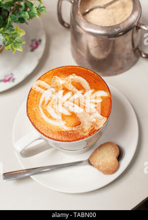 Tazza di cappuccino rosso (realizzata con rooibos tè) sormontato da una pioggerellina di miele in Quattro Venti & Cafe a Cape Town. Il tè è distintivo colore rosso ho Foto Stock