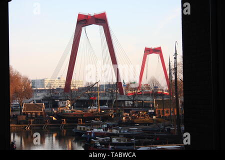 Willemsbrug, il ponte rosso di Rotterdam visto al tramonto sul porto Foto Stock