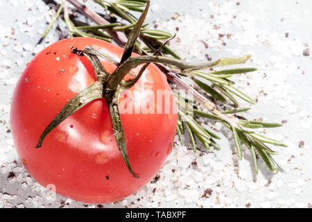 Rosso Pomodoro con rosmarino, pepe nero pestato e sale di mare su una piastra vintage Foto Stock