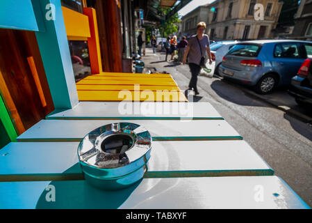 Bucarest, Romania - 21 Maggio 2019: un posacenere pieno di fumato sigarette su una sedia davanti a un coffee shop in Bucarest. Leggi europee vietano smok Foto Stock