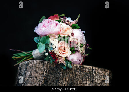 Wedding bouquet di rose con gli anelli sul banco di legno. Bridal bouquet di rose con anelli. Foto Stock