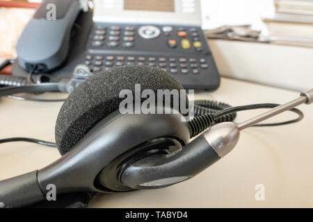 Cuffia con telefono in background in ufficio sulla scrivania Foto Stock