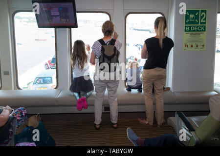 I passeggeri su un imbuto rosso traghetto tra terraferma britannica - Southampton - & Cowes sull'Isola di Wight guardare fuori dell'osservazione del parabrezza e finestrino giù sul ponte garage. Regno Unito. (99) Foto Stock