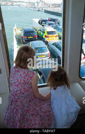 Bambino / Kids / passeggeri su un imbuto rosso traghetto tra terraferma britannica - Southampton - & Cowes sull'Isola di Wight guardare fuori dalla finestra e verso il basso sul ponte garage. Regno Unito. (99) Foto Stock