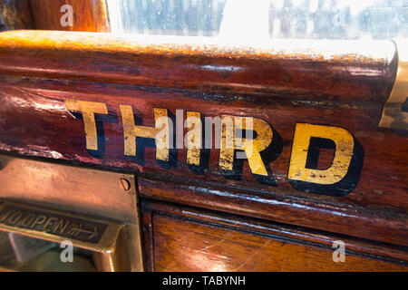 La terza parola (classe) dipinta in oro / lettere scritte sul slam porta con la cattura di un vecchio vintage treno a vapore carrello. England Regno Unito. (99) Foto Stock