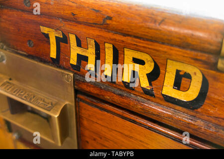 La terza parola (classe) dipinta in oro / lettere scritte sul slam porta con la cattura di un vecchio vintage treno a vapore carrello. England Regno Unito. (99) Foto Stock