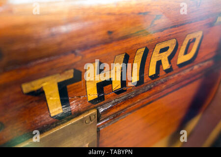 La terza parola (classe) dipinta in oro / lettere scritte sul slam porta con la cattura di un vecchio vintage treno a vapore carrello. England Regno Unito. (99) Foto Stock