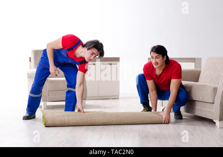 Due giovani contraente i dipendenti che si spostano oggetti personali Foto Stock