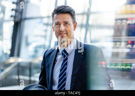 Ritratto di imprenditore sorridente in movimento Foto Stock