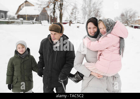 Nonno passeggiando insieme con la figlia e i nipoti in inverno Foto Stock