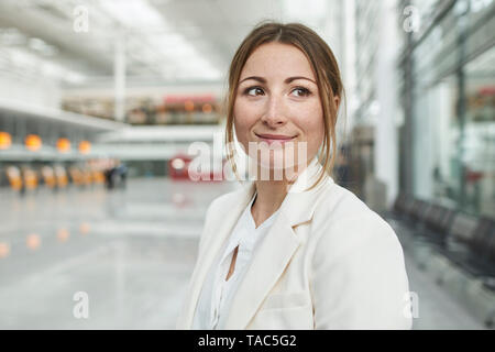 Ritratto di giovane sorridente imprenditrice all'aeroporto Foto Stock