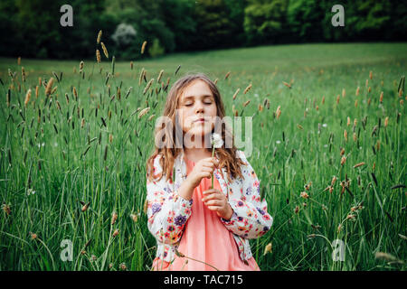Ritratto di ragazza con blowball su un prato Foto Stock