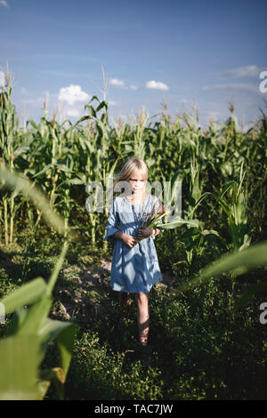 Ragazza bionda in piedi in un cornfield Foto Stock