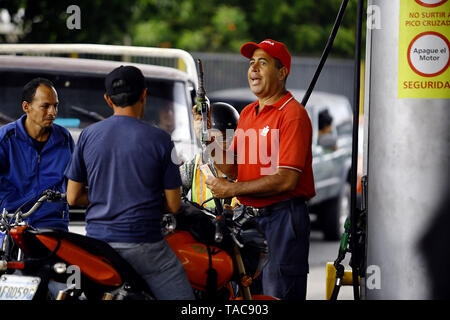 Guacara, Carabobo, Venezuela. 23 Maggio, 2019. Il 23 maggio 2019. Un pdvsa workerÂ"s alimenta la benzina di un veicolo motocicle presso la stazione di servizio la arboleda, nella città di Guacara, Carabobo stato. Foto: Juan Carlos Hernandezz Credito: Juan Carlos Hernandez/ZUMA filo/Alamy Live News Foto Stock