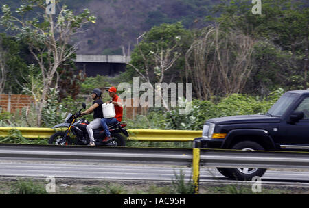 Guacara, Carabobo, Venezuela. 23 Maggio, 2019. Il 23 maggio 2019. Una coppia motorizzata spostare un container caricato con carburante, nella città di Valencia, Carabobo stato. Foto: Juan Carlos Hernandez Credito: Juan Carlos Hernandez/ZUMA filo/Alamy Live News Foto Stock