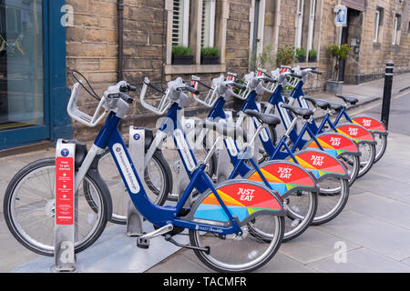 Cicli per il noleggio in corrispondenza di una stazione di aggancio a Stockbridge, Edimburgo. Sponsorizzato da solo mangiare Foto Stock