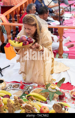 Una fervente adoratore indù che offre la divinità a un tempio in Giamaica, Queens, a New York Foto Stock