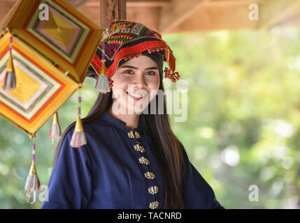 Asia donna stile tailandese dress tribù Tai Dam / Ritratto di giovane e bella ragazza sorridente Thailandia costume tradizionale che indossa con tessuto intessuto sulla testa Foto Stock