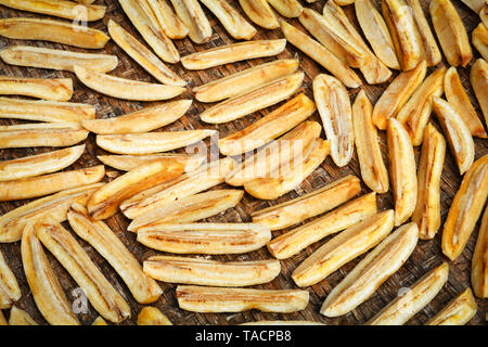 Banane essiccate background / organico lungo banana slice a secco su bamboo cestello di trebbiatura per essiccamento al sole Foto Stock