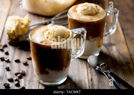 Caffè ghiacciato con gelato alla vaniglia chiamato affogato in Italia su una tavola in legno rustico Foto Stock