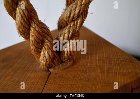 Un altamente textured loop della corda di pesca insieme in una boa di legno o dispositivo di galleggiamento su una luce interiore. Foto Stock