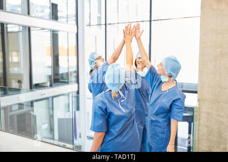 Successo del gruppo di chirurghi presso l'ospedale donano un alto cinque per la motivazione Foto Stock