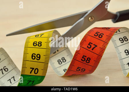Taglio a forbice del nastro di misura - Concetto di dieta e dimagrimento Foto Stock