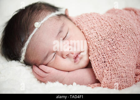 Dormire in wrap neonato ragazza close-up verticale Foto Stock