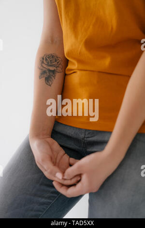 Close-up di una giovane donna con rose tattoo sul suo braccio Foto Stock
