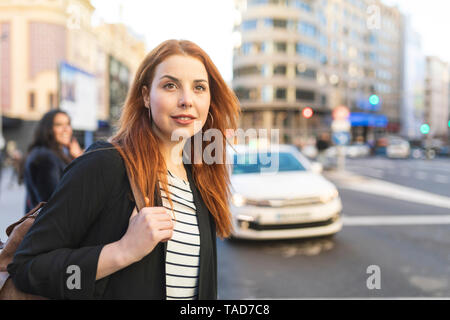 Ritratto di redheaded giovane donna con piercing per il naso in città Foto Stock