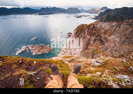 Norvegia Isole Lofoten Henningsvaer, escursionista seduta sul punto di visualizzazione Foto Stock