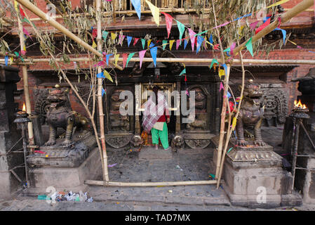 Donna adorando nel piccolo santuario indù a base di Bhairabnath Mandir, Taumadhi Tol, Bhakatapur, Valle di Kathmandu, Nepal Foto Stock