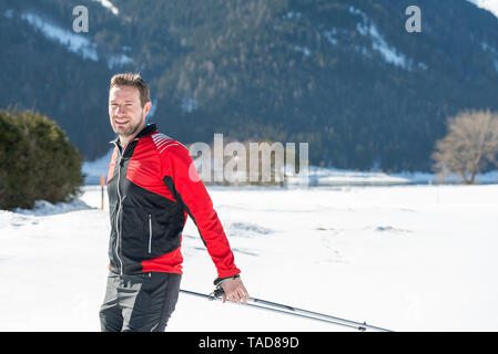 Austria, Tirolo, Achensee, ritratto di uomo sorridente fare sci di fondo Foto Stock