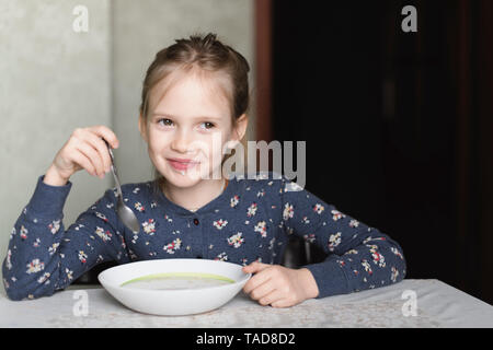 Ritratto di sorridente bambina mangiare farina di avena Foto Stock