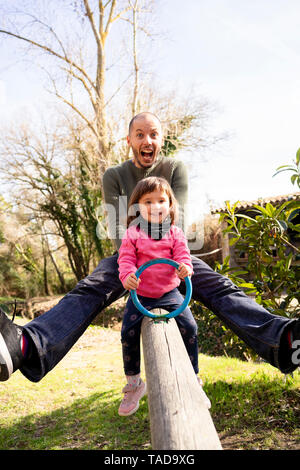 Ritratto di padre e figlia piccola divertirsi insieme su altalena Foto Stock