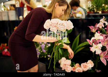 Donna disponendo dei fiori nel negozio di fiori Foto Stock