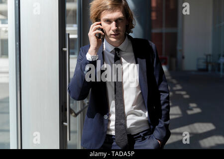 L'Italia, Firenze, giovane imprenditore sullo smartphone all'aperto Foto Stock