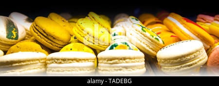 Pile di colorati macarons giacente in un file il caffè in camera, tradizionali biscotti francesi Foto Stock