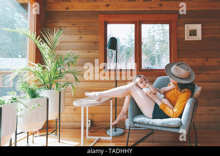 Mpother giocando con il suo bambino figlio nel lodge in legno Foto Stock